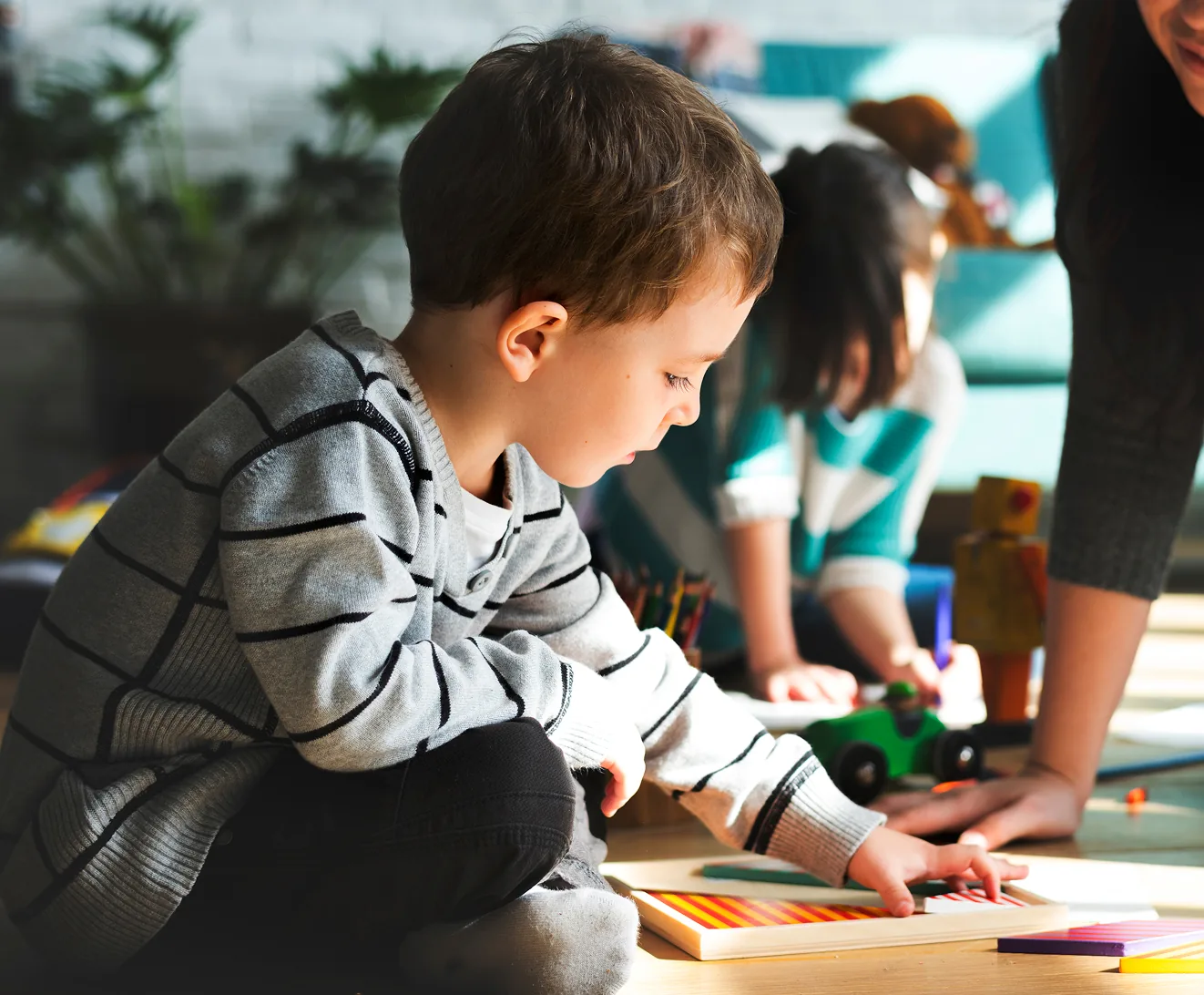 A child drawing at a table with crayons
