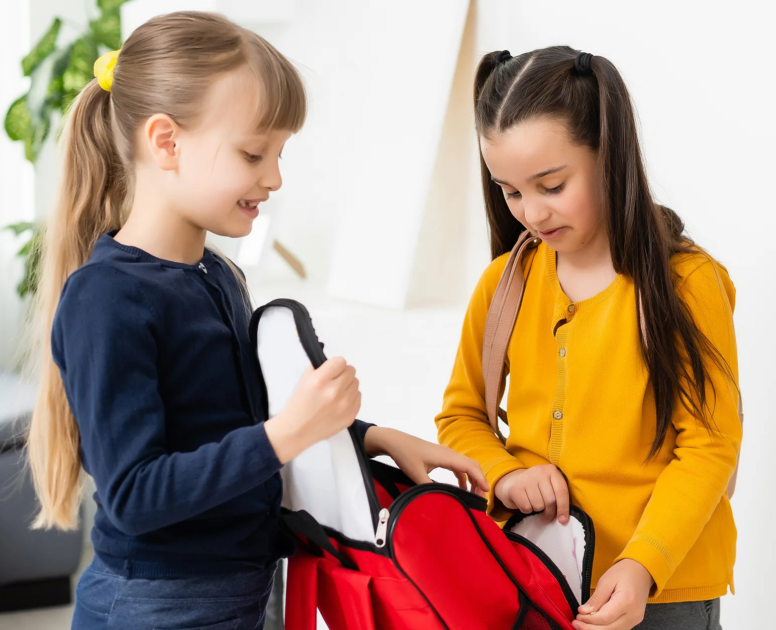 Two school-age children with backpacks getting ready in the morning